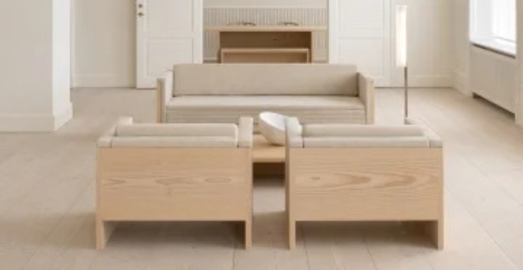 Lys stue med sofa og brede træplanker på gulvet.